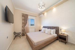 a bedroom with a bed and a flat screen tv at Gerasimos Dream House - 7 Minutes from the Airport in Lakíthra