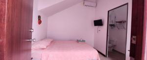 a small bedroom with a bed with a pink blanket at Casa Rosanna in Campeche +8 photos