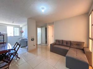 a living room with a couch and a dining room at Aconchego e praticidade ao lado da BR-040 in Luziânia