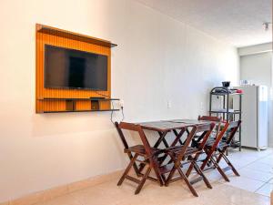 a dining room table with chairs and a television on a wall at Aconchego e praticidade ao lado da BR-040 in Luziânia +9 photos