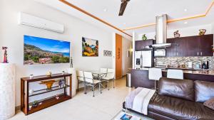 a living room with a couch and a kitchen at Penthouse Oceanview 1 block Malecon bars shops ZR in Puerto Vallarta