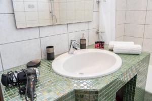 a bathroom counter with a sink and a camera on it at Gerasimos Dream House - 7 Minutes from the Airport in Lakíthra +23 photos