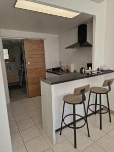 eine Küche mit zwei Barhockern und einer Theke in der Unterkunft Cassis la gare in Cassis