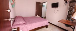 a small bedroom with a pink bed in a room at Casa Rosanna in Campeche