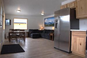 a kitchen and living room with a stainless steel refrigerator at The Cabins at Riptide Resort in Seward