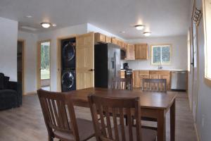 a kitchen with a wooden table with chairs and a dining room at The Cabins at Riptide Resort in Seward +4 photos