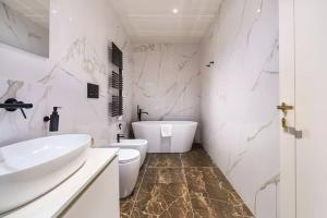 a white bathroom with a sink and a toilet at Palazzo Venezia in Florence