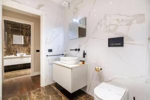 a white bathroom with a sink and a toilet at Palazzo Venezia in Florence