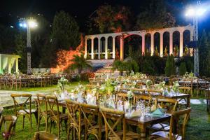an outdoor wedding with tables and chairs at night at Lunasol venue in Ar Rumayl