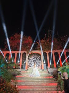 a bride walking down the stairs at night at Lunasol venue in Ar Rumayl
