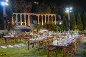 a long table set up for a party in a garden at night at Lunasol venue in Ar Rumayl