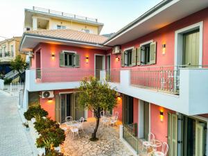 a building with tables and chairs on the balcony at ANAX APARTMENTS PARGA in Parga