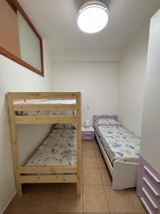 a bedroom with two bunk beds and a lamp at Ludovica's house 2 in Giardini Naxos
