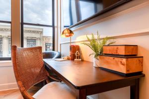 an office with a wooden table and a plant on it at Sinclair Suites - Boutique Hotel West Dundee in West Dundee