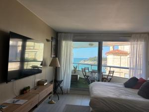 a bedroom with a bed and a view of the ocean at Prince Studio front de mer - residence luxe & thalasso in Biarritz +8 photos