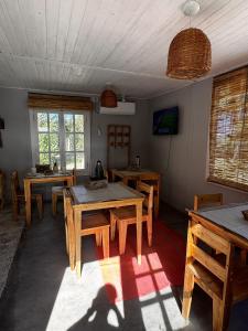 a dining room with tables and chairs and windows at Dormis El Alba in Barreal