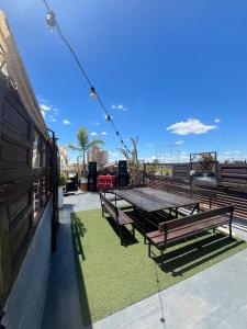 a picnic table and benches on a patio at Republica Hostel in San Pedro