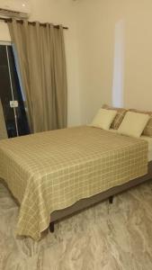 a large bed in a room with a window at Onda's suíte in Paraty
