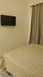 a bedroom with a bed with a checkered blanket at Onda's suíte in Paraty