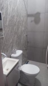 a bathroom with a white toilet and a sink at Onda's suíte in Paraty