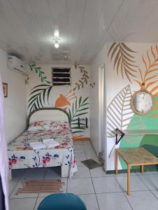 a bedroom with a bed and a clock on the wall at Pousada Vila Formosa in Belém