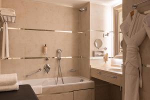 a bathroom with a tub and a sink at Hotel Renoir in Cannes +24 photos