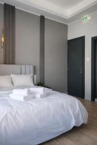 a white bed with two towels on top of it at Mézzo Lago in Missolonghi +12 photos