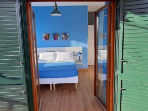 a room with a bed with a blue wall at Casa Annalisa in Scauri
