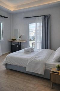 a bedroom with a large white bed with a window at Mézzo Lago in Missolonghi