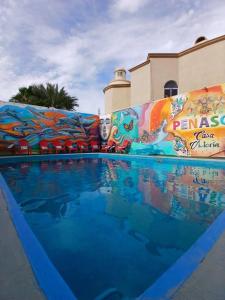 a swimming pool at a resort with a mural at Hotel Casa Victoria in Puerto Peñasco