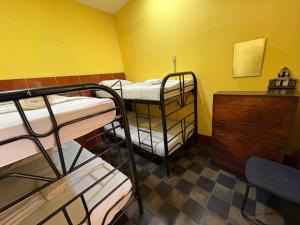 a room with three bunk beds and a dresser at Hostal los Cheles in León