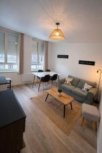 a living room with a couch and a table at Douce Escale - 1 chambre - literie premium in Calais +1 photo