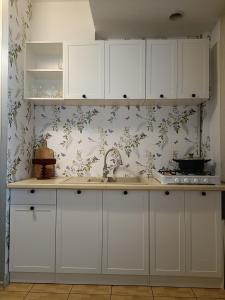 a kitchen with white cabinets and floral wallpaper at Agroturystyka Wypoczynek na Wsi in Słowiki Nowe +26 photos