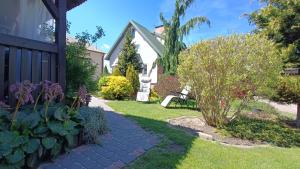 a house with a garden with flowers and a walkway at Agroturystyka Wypoczynek na Wsi in Słowiki Nowe