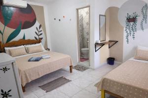 a bedroom with two beds and a bathroom at Pousada Vila Formosa in Belém