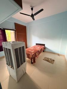 a room with a fan and a bed in it at Apna Ghar in Bhopal +5 photos