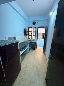 a room with a kitchen with a counter and a door at Apna Ghar in Bhopal