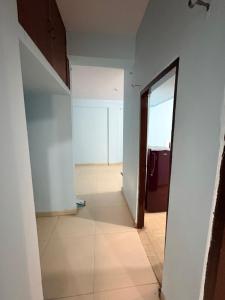 an empty room with a mirror and a hallway at Apna Ghar in Bhopal