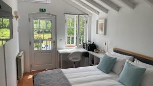 a white bedroom with a bed and a sink at Campos Essencia in Arganil