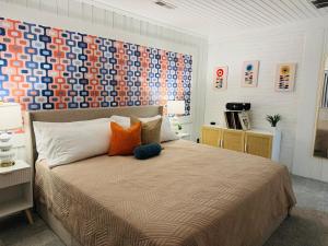 a bedroom with a bed with an orange and blue headboard at Retro Retreat in Wilson +33 photos