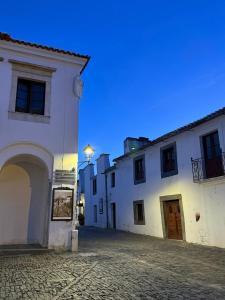 a group of white buildings on a cobblestone street at Casa Rama D Oliveira in Barrada