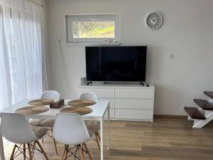 a living room with a white table and a tv at Duna Panoráma Vendégház in Mohács