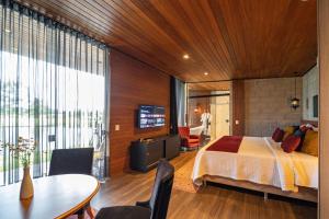 a bedroom with a bed and a table and chairs at Pousada Recanto do Sambaqui in Balsa Nova