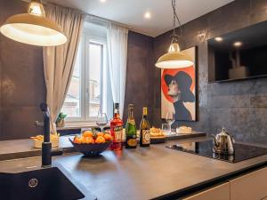 a kitchen with a counter with bottles and a bowl of fruit at MYō in Dorno