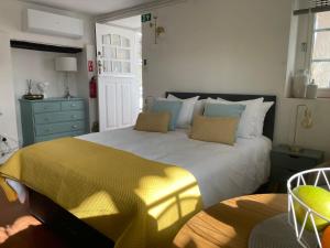 a bedroom with a large bed with a yellow blanket at Campos Essencia in Arganil