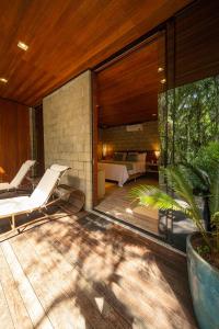 a house with a deck with a bed and a bedroom at Pousada Recanto do Sambaqui in Balsa Nova