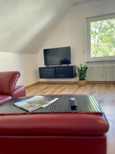 a living room with a red couch and a tv at Haus87a in Oberkirch +10 photos