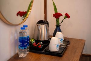 a tray with a coffee maker and two vases with flowers at Minh Chau Beach Resort in Quang Ninh