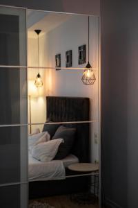 a room with a bed and a table and lights at Seyra Home Studio - Modern Flat Pool Free Parking Self Check-in in Ştefăneştii de Sus
