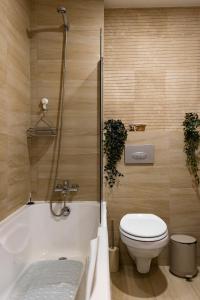 a bathroom with a toilet and a tub and a sink at Seyra Home Studio - Modern Flat Pool Free Parking Self Check-in in Ştefăneştii de Sus +23 photos